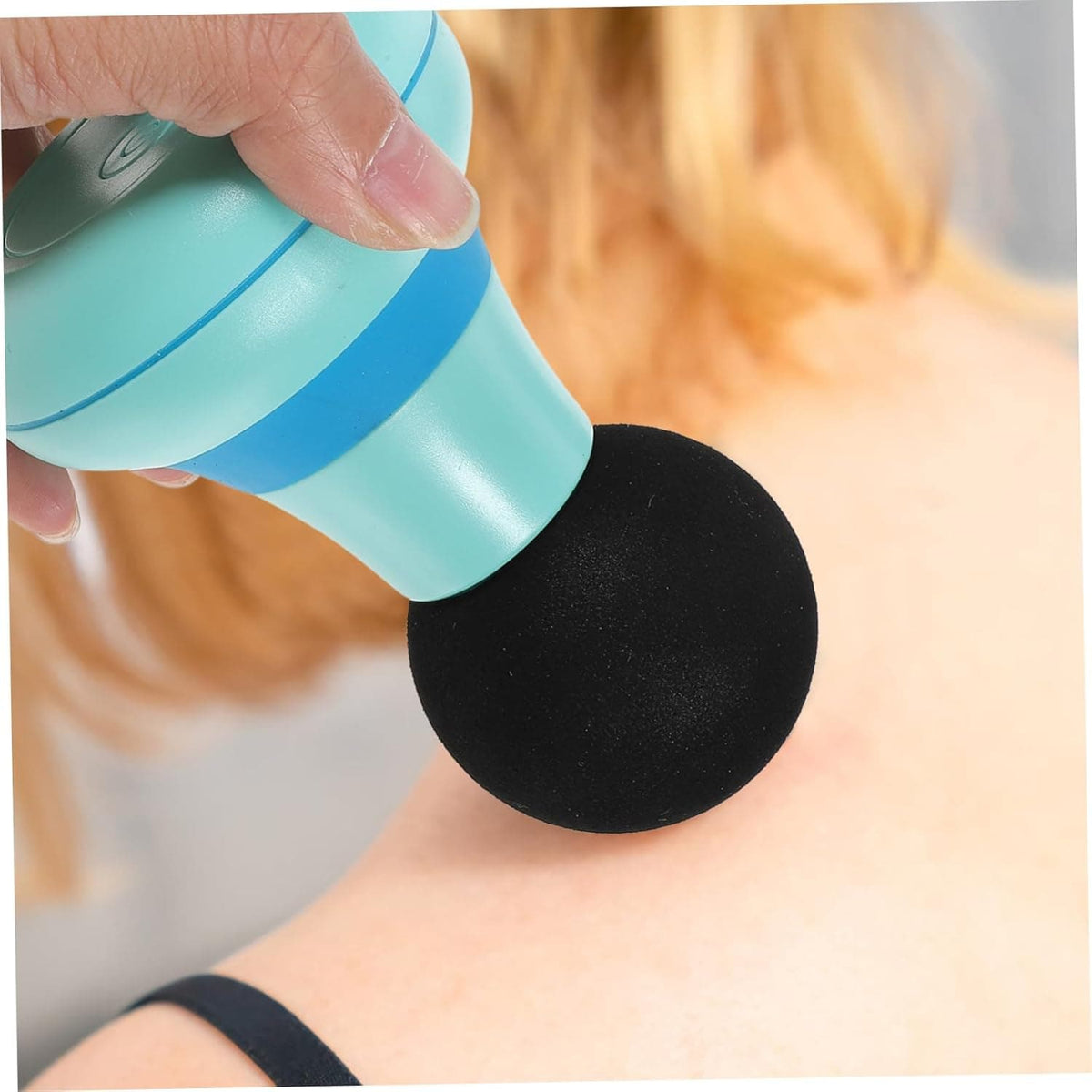 Mini appareil de massage pour cervicale – gros plan sur la tête noire en contact avec la nuque d'une personne, couleur turquoise, design compact