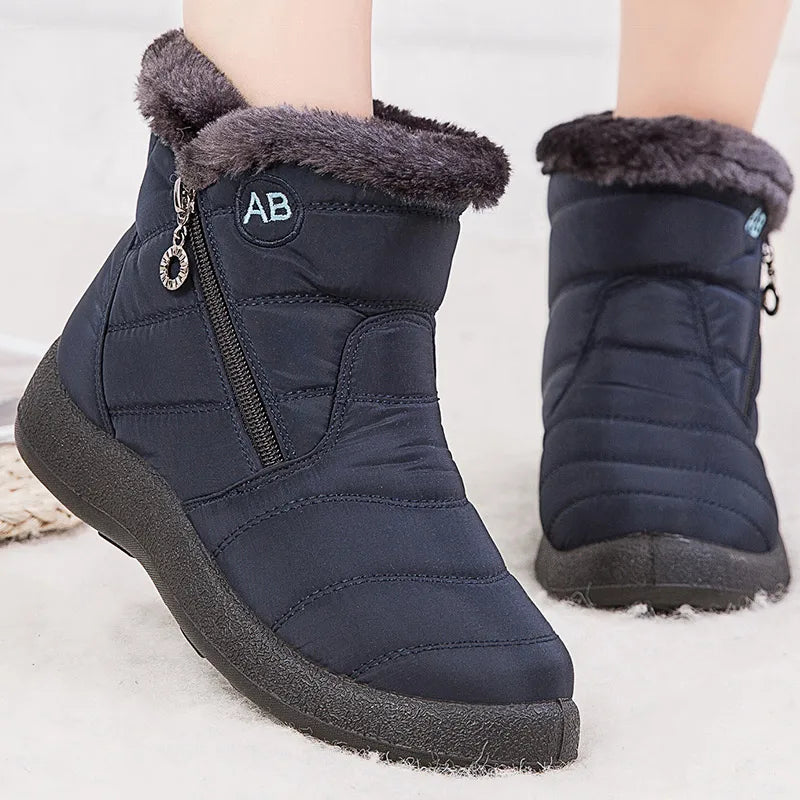 Boots Imperméable Femme en tissu bleu marine avec col en fourrure grise, vue de près, dotées d'une fermeture éclair sur le côté.