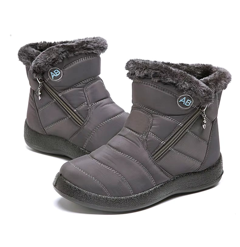 Boots Imperméable Femme en gris avec col en fourrure, vue latérale mettant en avant les fermetures éclair et la semelle antidérapante.