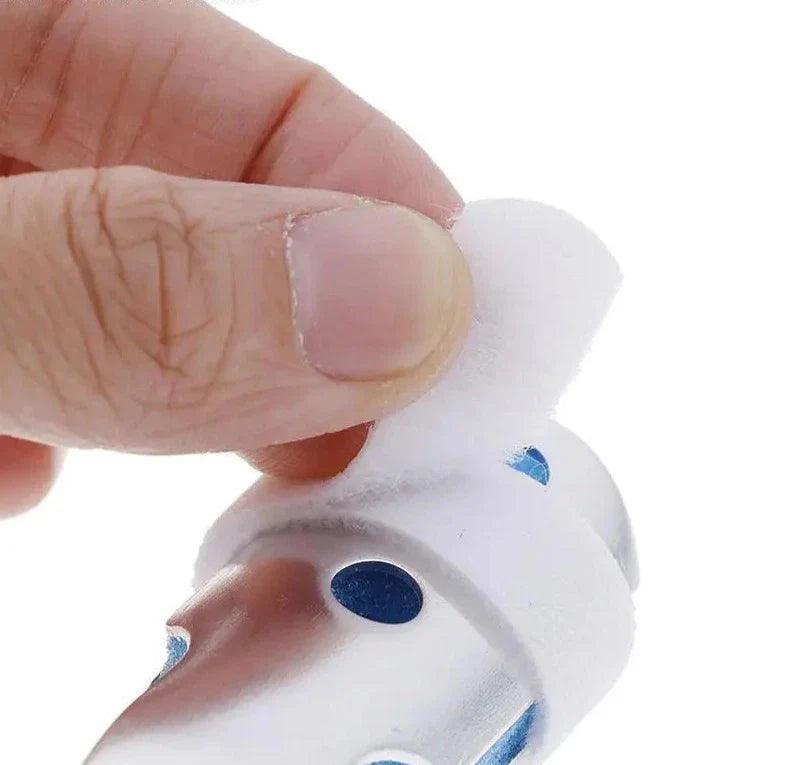 Attelle auriculaire – détail de la fixation en tissu doux sur un support en métal, vue rapprochée avec main tenant l'élément