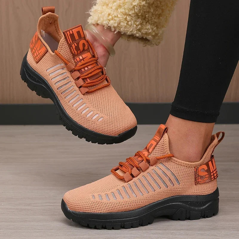 Basket orthopédique femme - Chaussures légères et respirantes de couleur pêche avec des détails en mesh, portées par une personne en position debout.