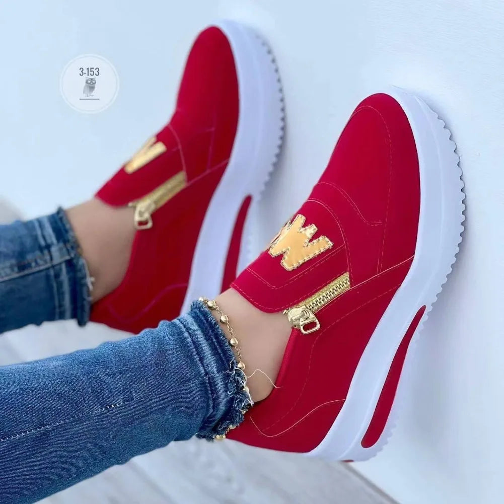 Basket orthopédique femme - Sneakers rouges avec zip doré, portées avec un jean et un bracelet sur fond clair