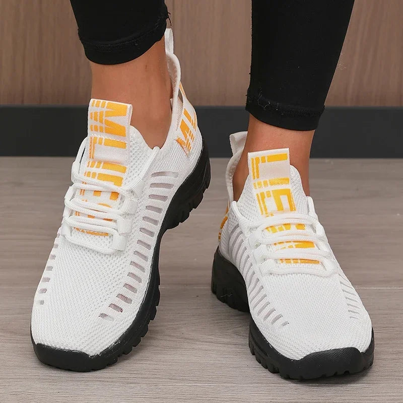 Basket orthopédique femme - Chaussures légères et respirantes de couleur blanche avec des détails en mesh, vues de près sur des pieds chaussés.