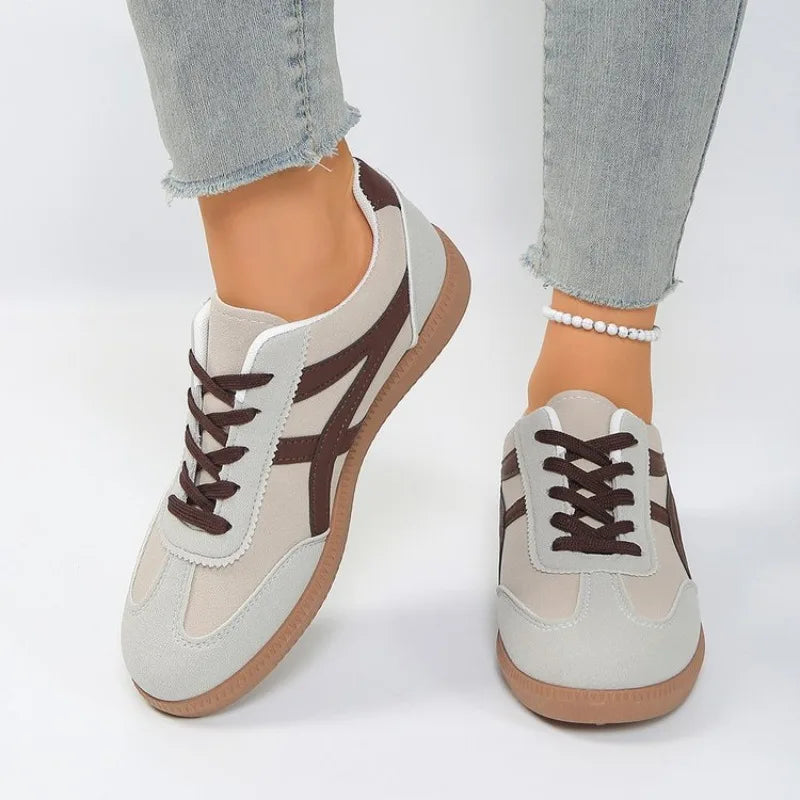 Basket orthopédique femme - Sneakers blanches avec détails marron, portées avec un jean, vue de face
