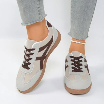 Basket orthopédique femme - Sneakers blanches avec détails marron, portées avec un jean, vue de face
