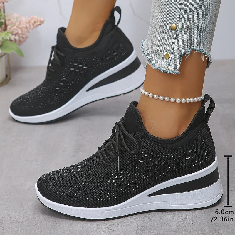 Basket orthopédique femme - Sneakers compensées noires à strass, portées avec un pantalon en jean, vue latérale, en mesh respirant.