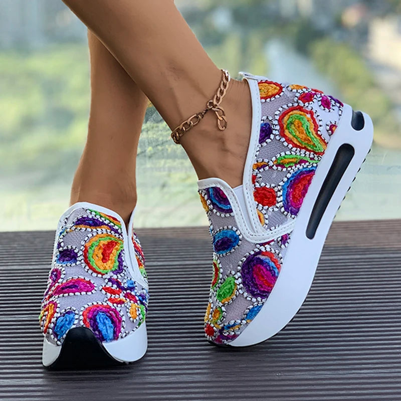 Basket orthopédique femme - Sneakers légères en mesh respirant avec motifs colorés et semelle blanche, portées par une femme.