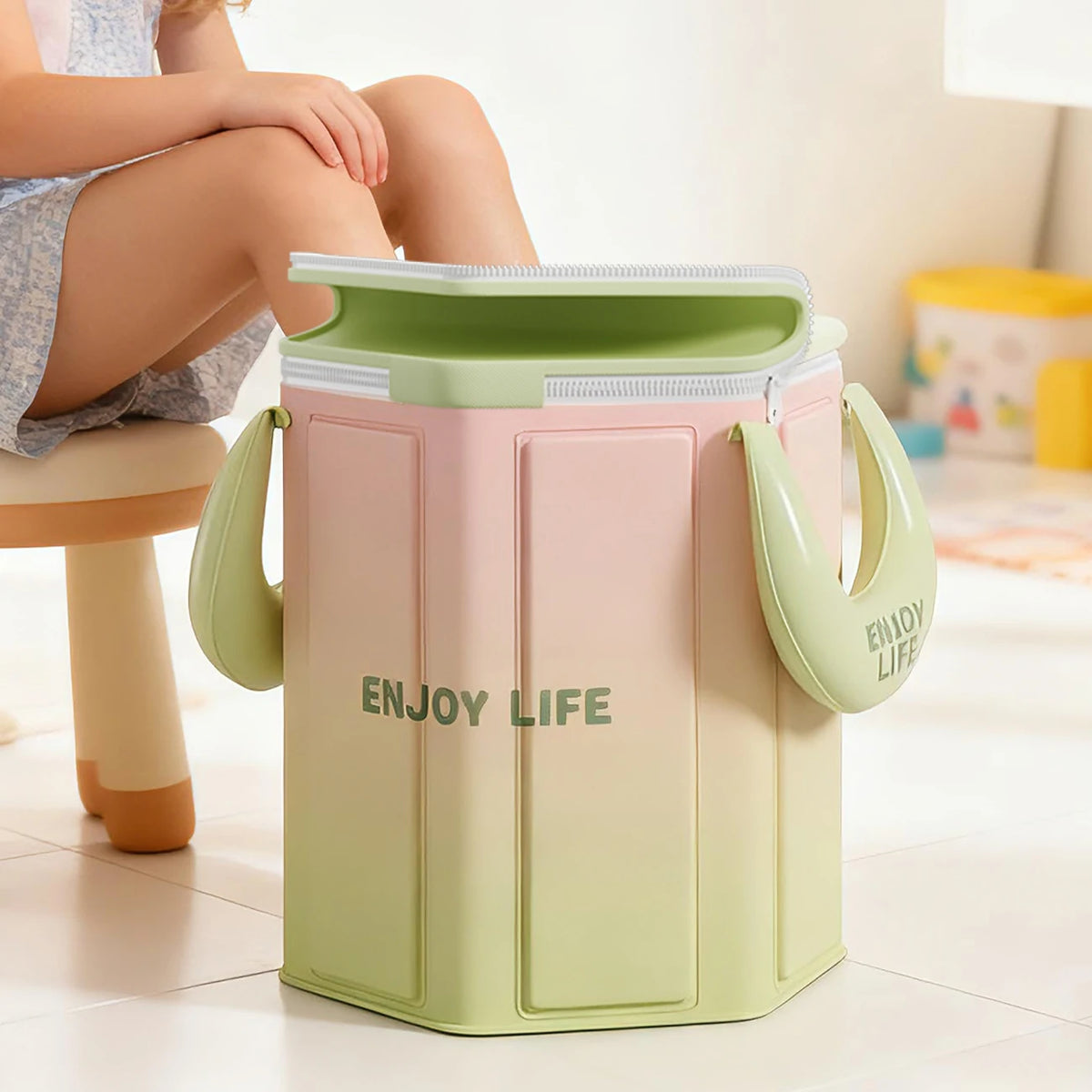 Bain de pied - Bassin pliable portable pour pédicure à domicile, vue de face avec design en dégradé de couleurs vert et rose, poignées visibles.