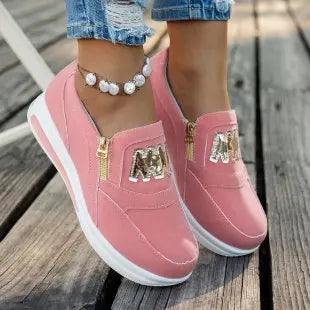 Basket orthopédique femme - Sneakers roses avec zip doré, portées avec un jean déchiré, vue de près sur un sol en bois