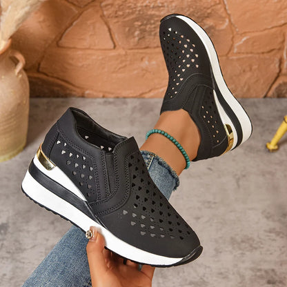 Basket orthopédique femme - Sneakers à semelle épaisse en cuir PU respirant, couleur noire, avec perforations, portées avec un jean.