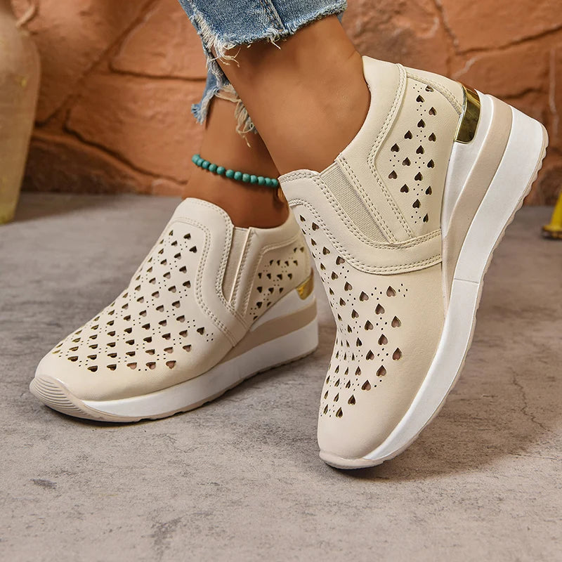 Basket orthopédique femme - Sneakers à semelle épaisse en cuir PU respirant avec perforations et design élégant, portées avec un jean décontracté.