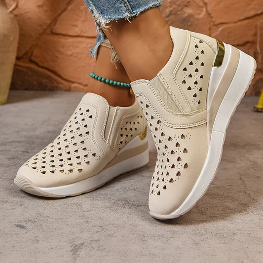 Basket orthopédique femme - Sneakers à semelle épaisse en cuir PU respirant avec perforations et design élégant, portées avec un jean décontracté.