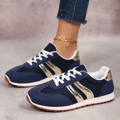 Basket orthopédique femme - Sneakers légères en mesh bleu marine avec détails argentés, vue de côté sur un sol clair.