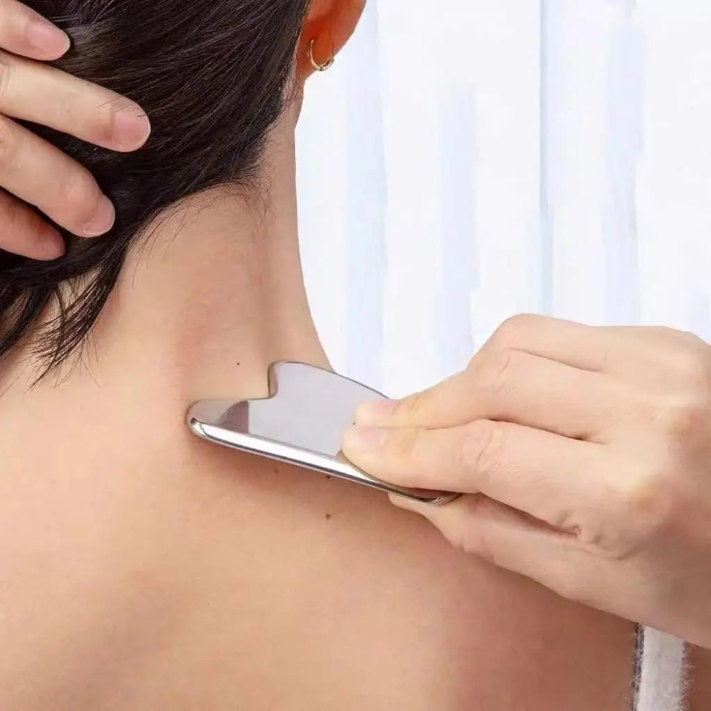 Appareil massage visage en acier inoxydable – utilisé sur le cou d'une femme, montrant la forme ergonomique et la finition lisse