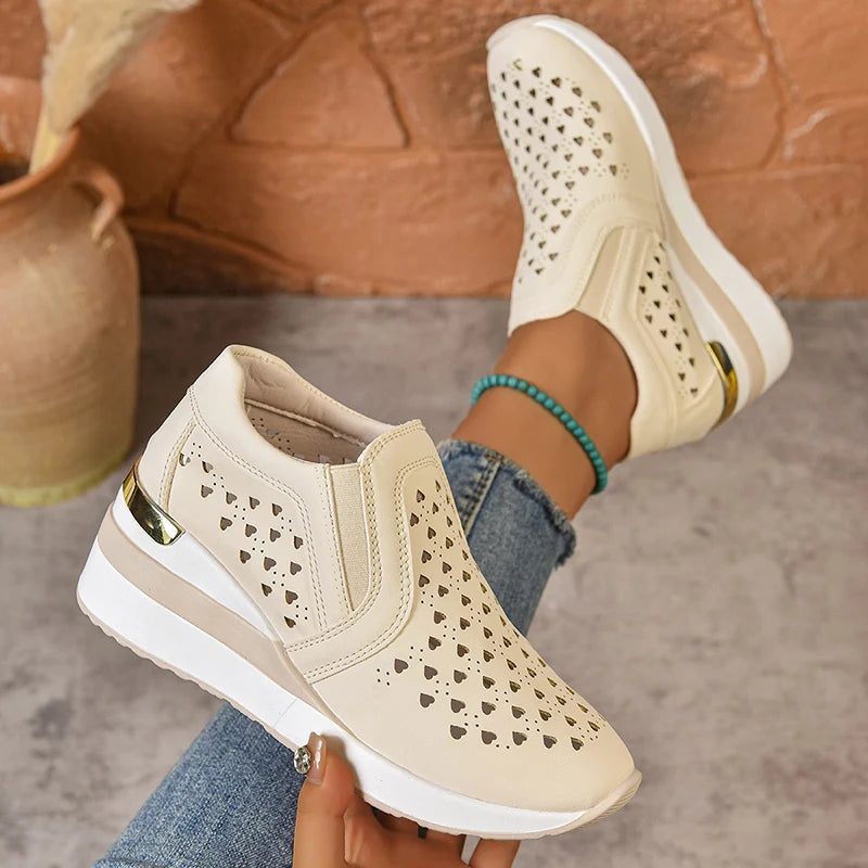 Basket orthopédique femme - Sneakers à semelle épaisse en cuir PU respirant avec perforations en forme de cœur, couleur beige, portée avec un jean.