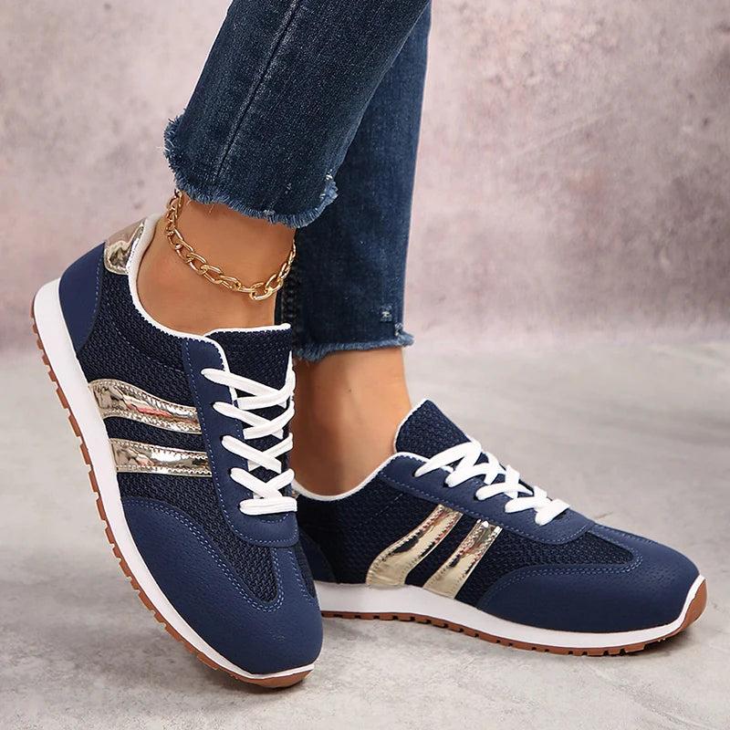 Basket orthopédique femme - Sneakers légères en mesh bleu marine avec détails dorés, portées avec un jean, vue de côté.