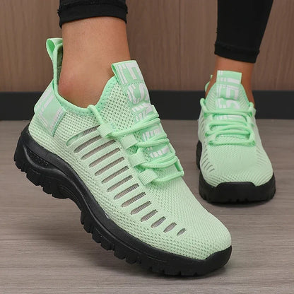 Basket orthopédique femme - Chaussures légères et respirantes de couleur verte avec des détails en mesh, portées par une personne en position debout.