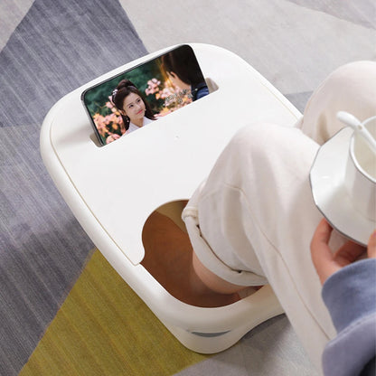 Bain de pied - Bassin pliable ergonomique pour usage à domicile et en – bassin blanc avec une personne assise, les pieds dans l'eau, tenant une tasse.
