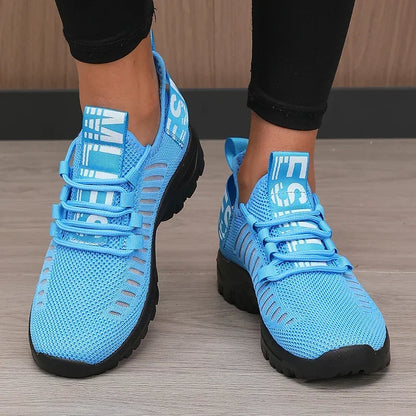 Basket orthopédique femme - Chaussures légères et respirantes de couleur bleue avec des détails en mesh, présentées de face sur un sol en bois.