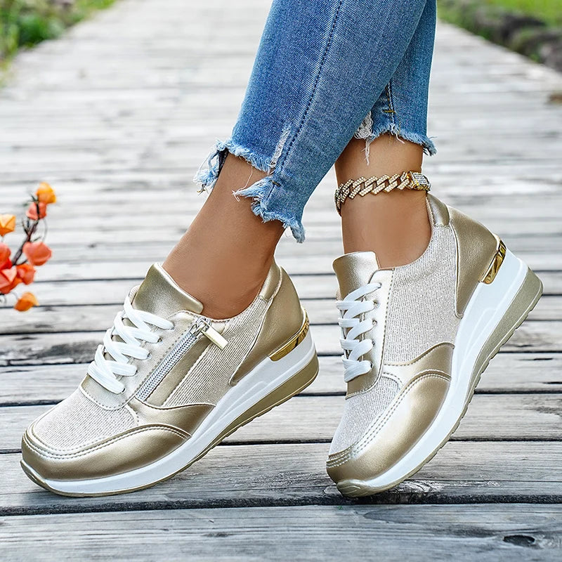 Basket orthopédique femme - Sneakers compensées en mesh doré, portées avec un jean déchiré sur un chemin en bois, détails dorés et zip sur le côté