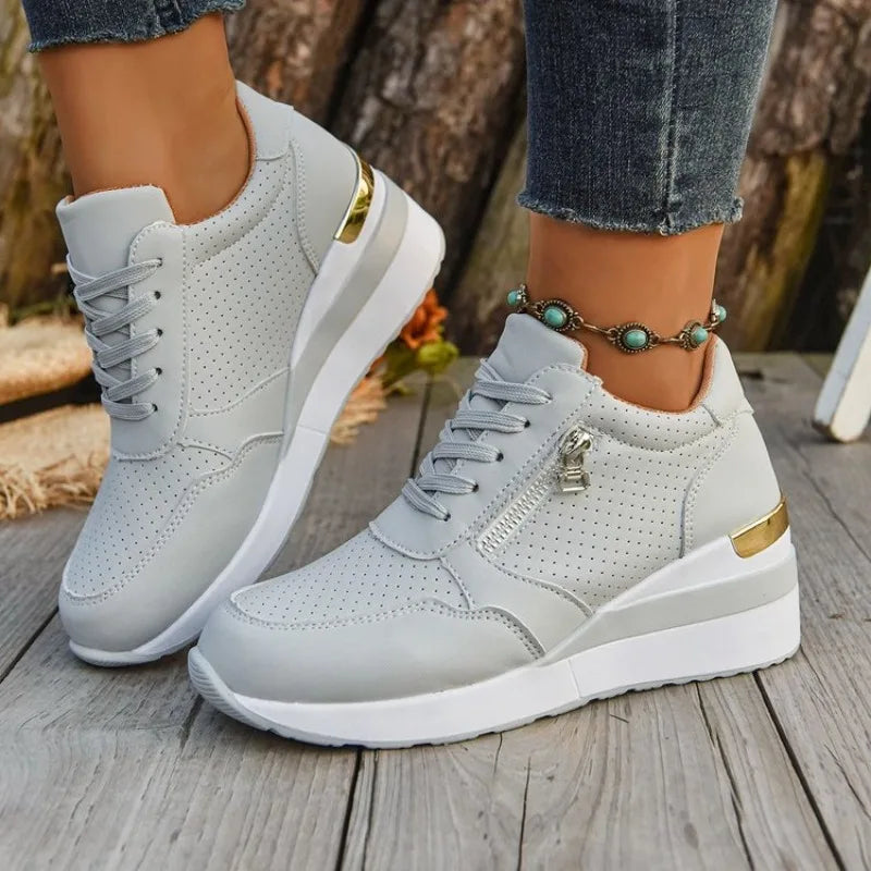 Basket orthopédique femme - Sneakers légères à semelle épaisse et, vue en détail sur pieds, couleur grise avec zip et semelle blanche.