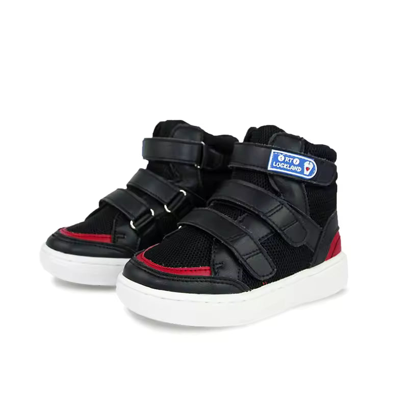 Chaussures orthopédiques enfant FlexiFit – Baskets noires avec détails rouges et fermetures velcro, vue de face sur fond blanc.