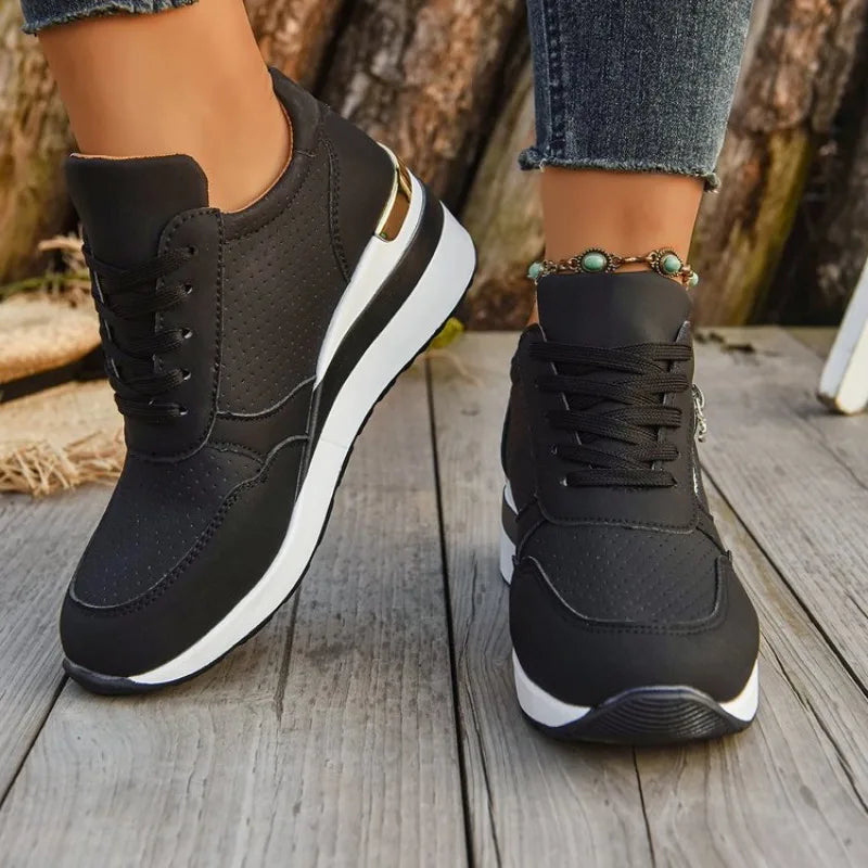 Basket orthopédique femme - Sneakers légères à semelle épaisse et, vue en détail sur pieds, couleur noire avec semelle blanche.