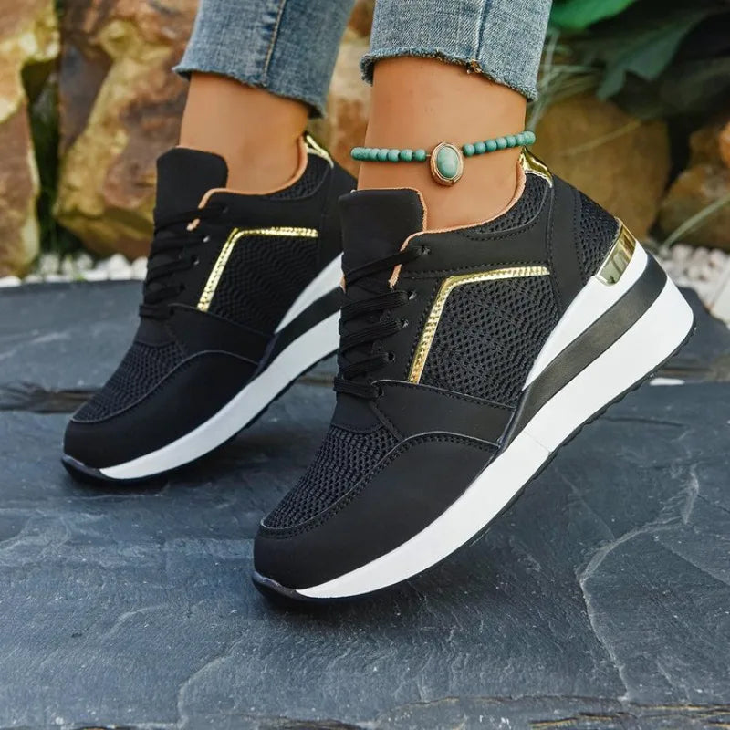 Basket orthopédique femme - Sneakers légères noires avec détails dorés et semelle épaisse, portées avec un bracelet au poignet.