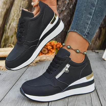 Basket orthopédique femme - Sneakers légères noires à semelle antidérapante avec zip décoratif, portées sur une terrasse en bois.