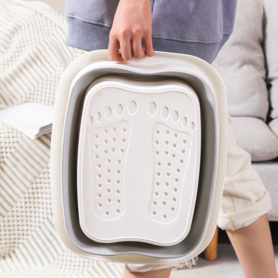 Bain de pied - Bassin pliable ergonomique pour usage à domicile et en – bassin plié, de couleur beige et gris, tenu par une personne, vue de côté.