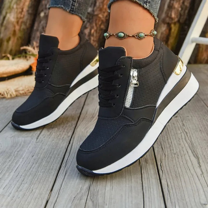 Basket orthopédique femme - Sneakers légères à semelle épaisse et, vue de près sur pieds, couleur noire avec zip et semelle blanche.