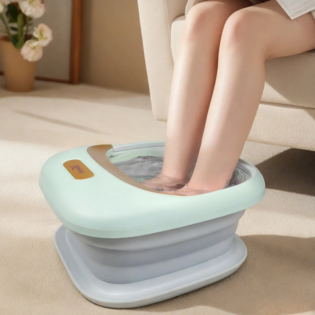 Bain de pied - Bassin pliable avec pieds immergés dans l'eau, design moderne en vert et gris, utilisé sur un tapis beige.