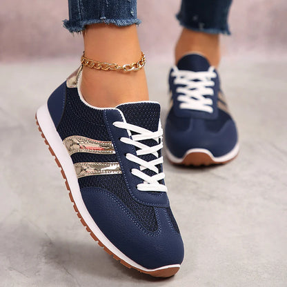Basket orthopédique femme - Sneakers légères en mesh bleu marine avec bandes dorées, portées avec un jean, vue de près sur les pieds.