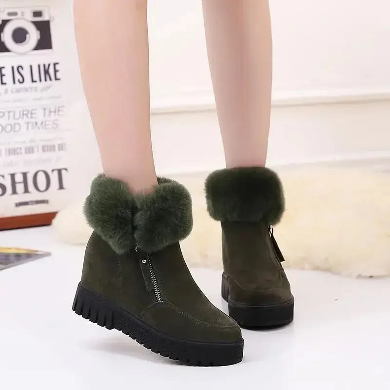 Boots Fourrure Femme en cuir suédé vert avec col en fourrure douce et fermeture éclair sur le côté, portées par une femme.