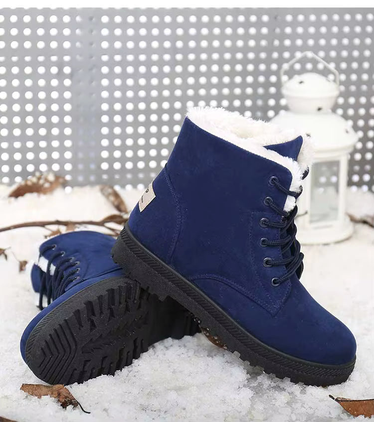 Bottines à Lacets Femme en cuir synthétique bleu marine avec intérieur en fourrure blanche, semelle antidérapante, posées sur la neige.