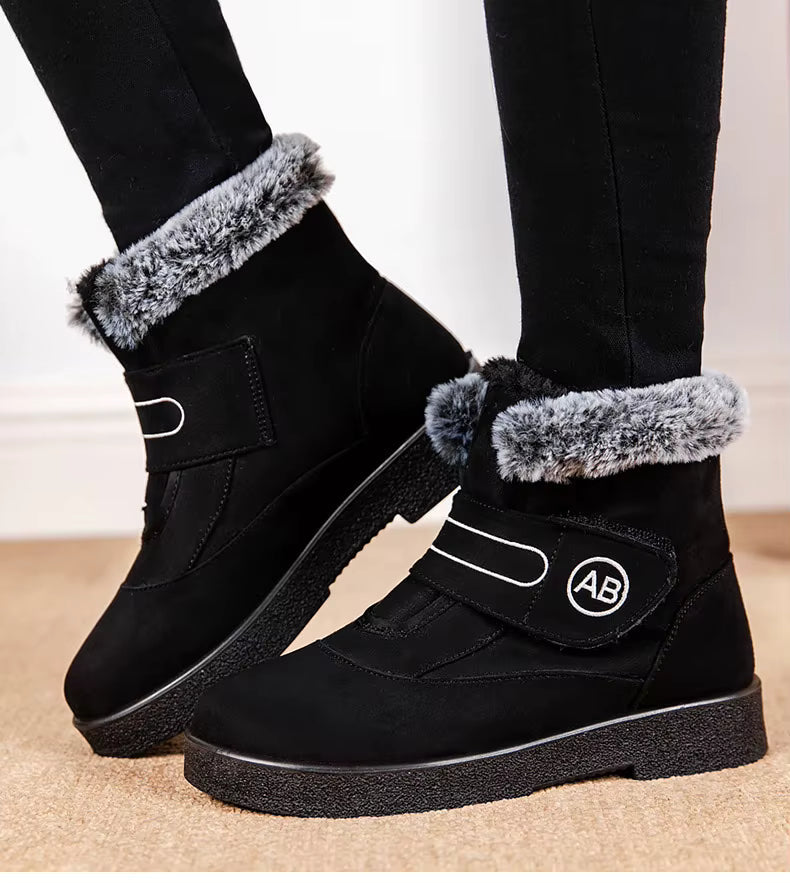 Bottines Femmes - Modèle AB en noir avec fourrure grise, vue de côté, semelle antidérapante et fermeture velcro visible.