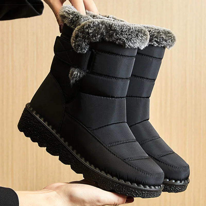 Bottines de Neige Femme : Élégance et Performance Hivernale – Bottines noires avec fourrure grise et semelle crantée, présentées en main