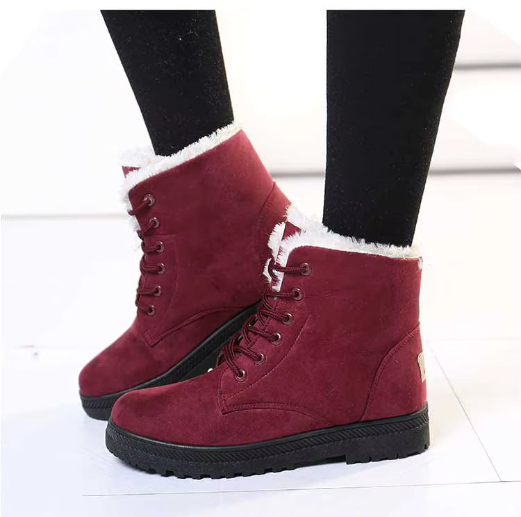 Bottines à Lacets Femme en cuir synthétique bordeaux avec doublure en fourrure, semelle épaisse et lacets visibles, portées avec des collants noirs.