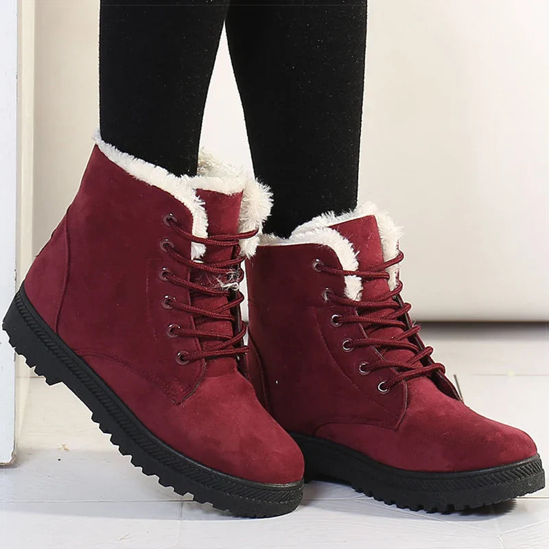 Bottines à Lacets Femme en suède bordeaux avec doublure en fourrure, portées avec des leggings noirs, sur un sol clair.
