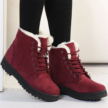 Bottines à Lacets Femme en suède bordeaux avec doublure en fourrure, portées avec des leggings noirs, sur un sol clair.