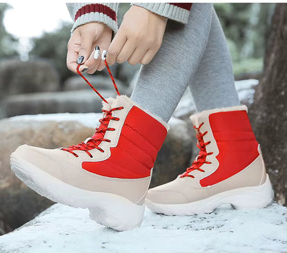 Chaussures d'Hiver Femme : Élégance et Confort – Bottes beige et rouge avec lacets, portées sur un chemin enneigé, détails de la semelle visible.