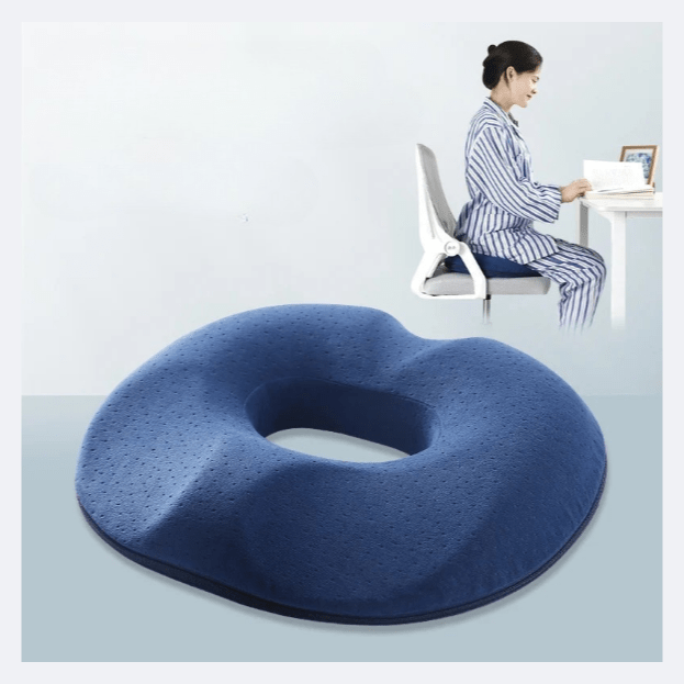 Coussin Orthopédique Dos à Mémoire de Forme Style Donut – coussin bleu en mousse à mémoire de forme, vue latérale avec une personne assise à un bureau