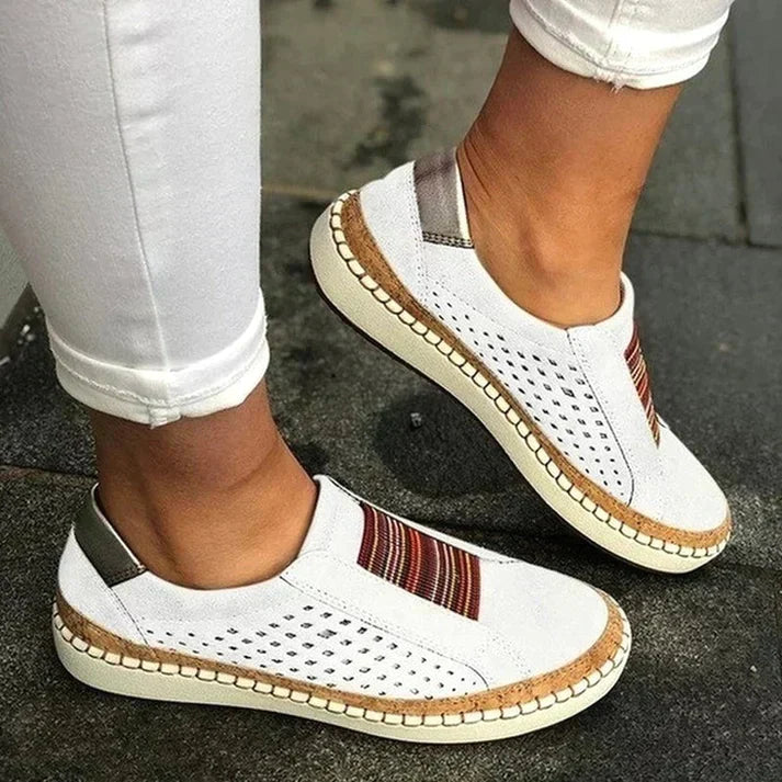 ADINA™ | Baskets orthopédiques confortables et élégantes – Baskets blanches avec détails colorés, portées avec un pantalon blanc, vue de côté