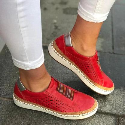 ADINA™ | Baskets orthopédiques confortables et élégantes – Baskets rouges avec perforations, portées avec un pantalon blanc, vue de près
