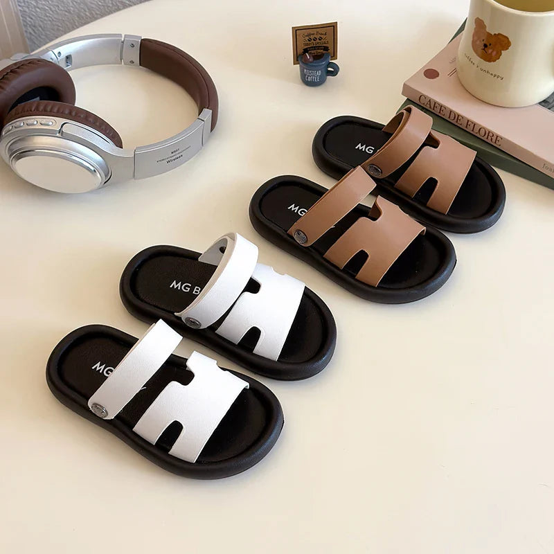Sandales cuir enfant – Modèle avec lanières blanches et marron sur semelle noire, vue générale sur table